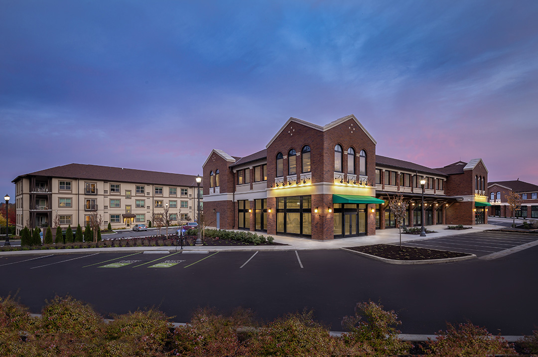 Exterior and parking lot shot of residential complex, with sunset in background